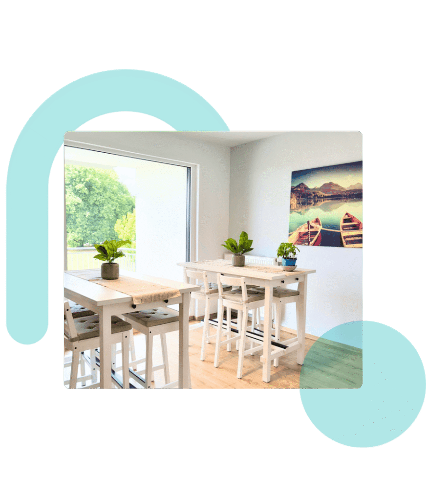 Montiertes Bild: nikan office Küche mit Blick auf Balkon und Park, weiße Stehtische, mintfarbene Wand, Kanu-Bild.transparentes Logo-Wasserzeichen